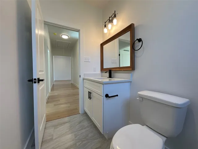 a bathroom with a toilet a sink and mirror