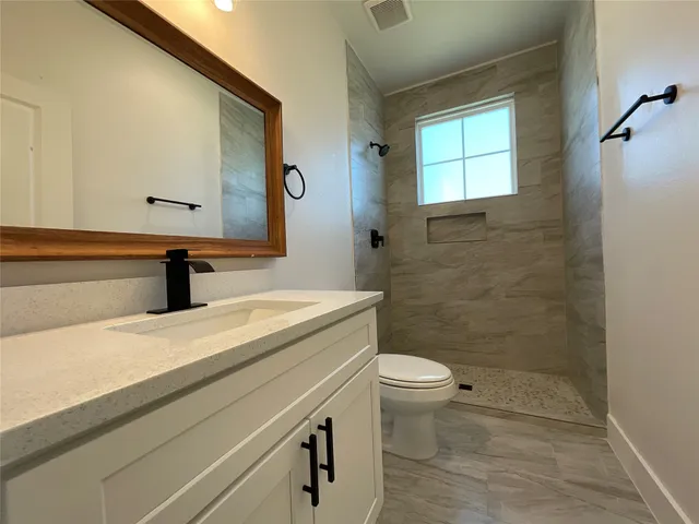 a bathroom with a sink a toilet and shower