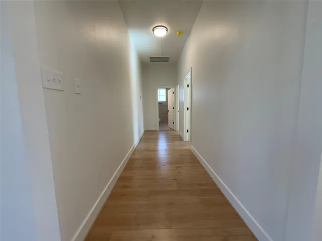 a view of a hallway with wooden floor