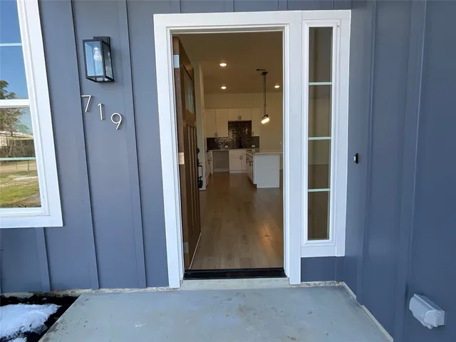 a view of a hallway with a livingroom and a bathroom