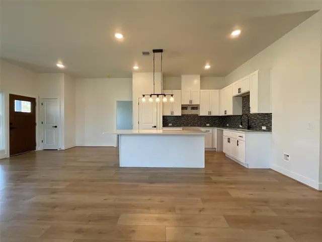 a large kitchen with kitchen island a sink stainless steel appliances and cabinets