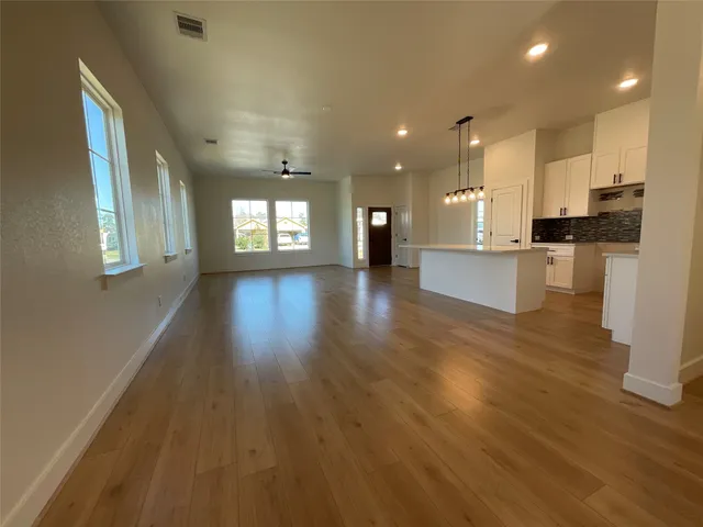 a view of large kitchen with a sink and wooden floor