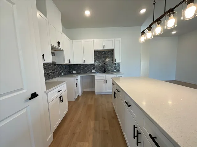 a large kitchen with stainless steel appliances sink a stove and cabinets