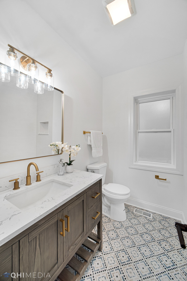 5459 West Grace Street Chicago, IL 60641 - Photo 13 of 24 a bathroom with a sink a toilet and mirror