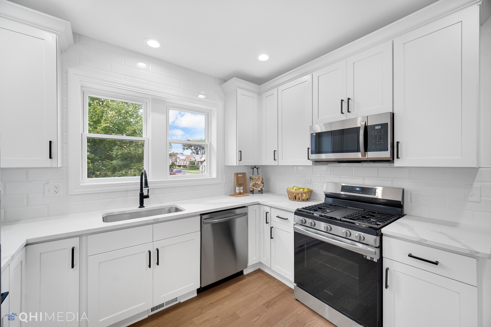 5459 West Grace Street Chicago, IL 60641 - Photo 6 of 24 a kitchen with white cabinets appliances a sink and a window