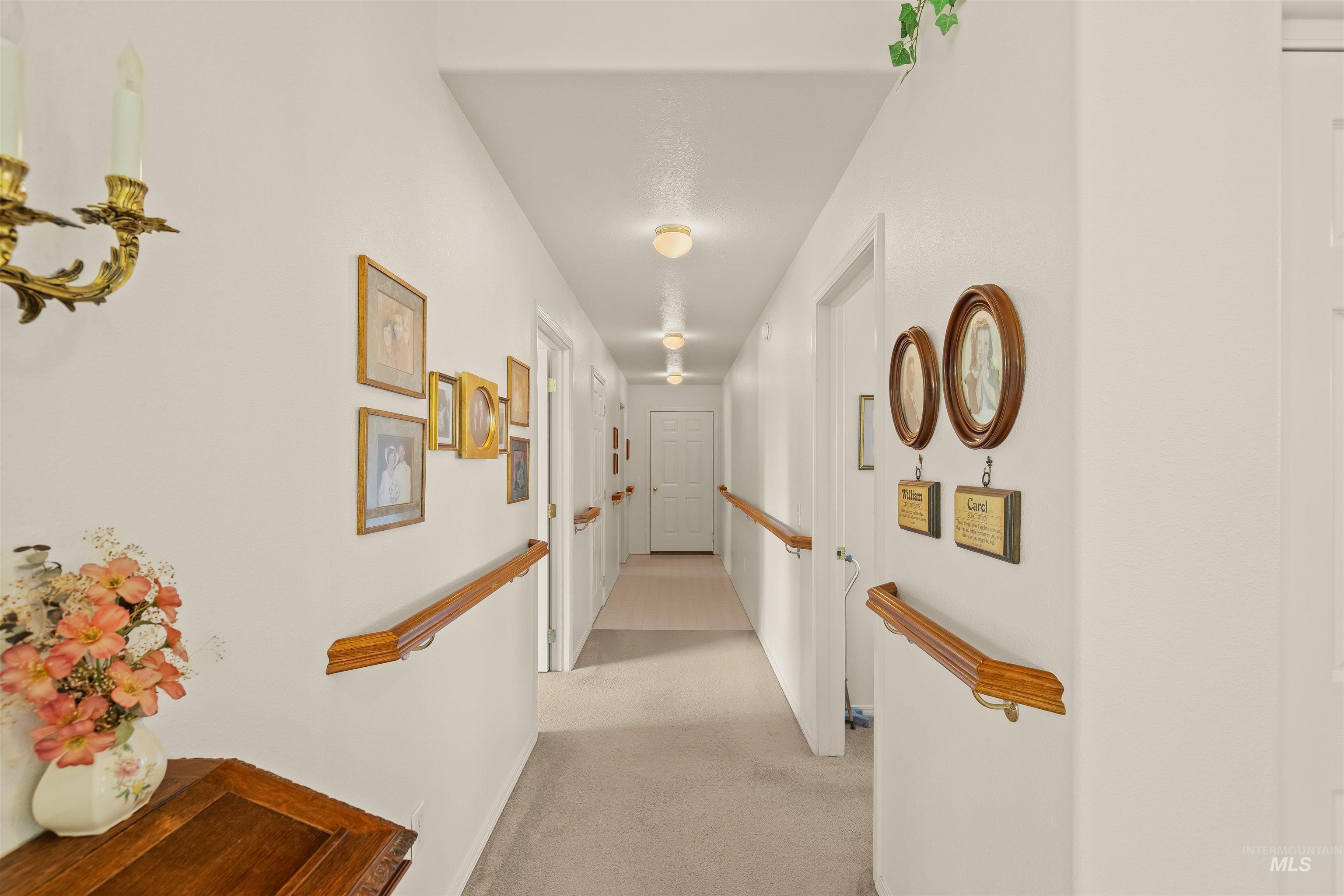 743 Wall Crk Road Stites, ID 83552 - Photo 28 of 48 Hallway featuring wood-finish handrails, white paneled doors, and recessed ceiling lighting