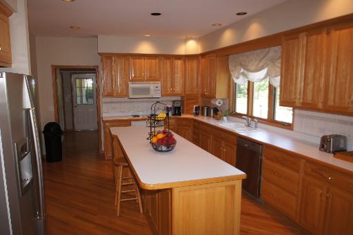 36W916 Valleyview Road Dundee, IL 60102 - Photo 3 of 16 a kitchen with a refrigerator a sink and wooden cabinets