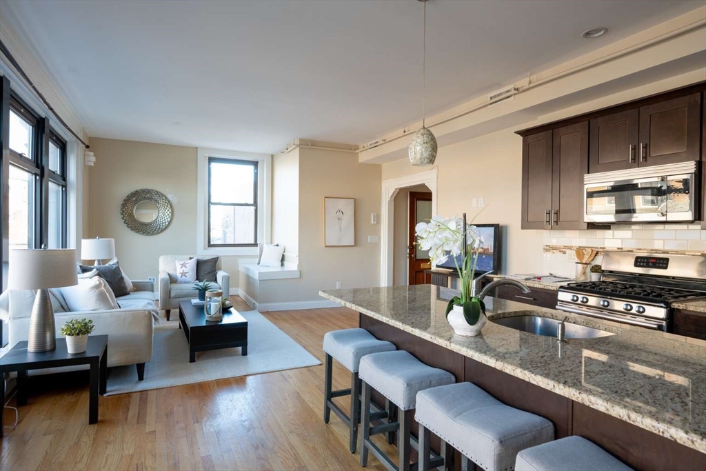 a living room with furniture kitchen view and a window