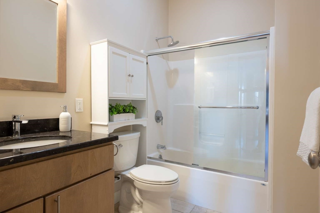 191 Main Street, Unit 2A Gloucester, MA 01930 - Photo 7 of 15 a bathroom with a granite countertop sink toilet and shower