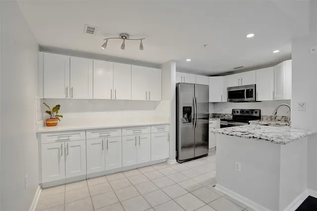 a kitchen with white cabinets and appliances