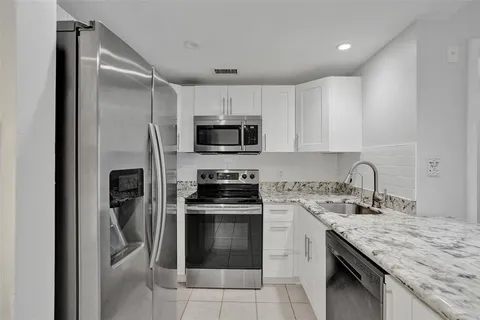a kitchen with stainless steel appliances granite countertop a refrigerator stove and microwave