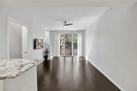 a kitchen with stainless steel appliances granite countertop a stove top oven a sink dishwasher and a refrigerator with wooden floor