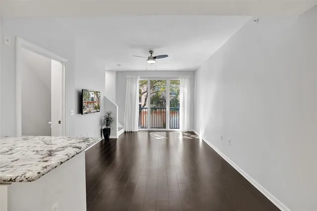 a kitchen with stainless steel appliances granite countertop a stove top oven a sink dishwasher and a refrigerator with wooden floor