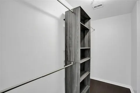 a view of walk in closet with empty racks