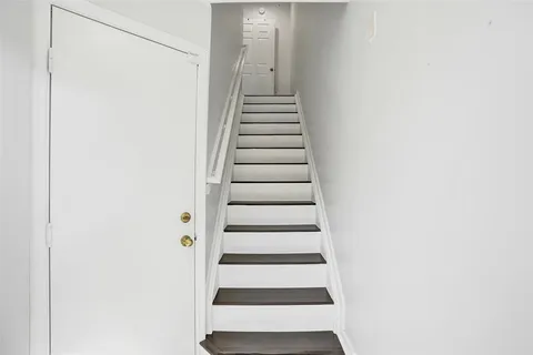 a view of entryway with stairs and white walls
