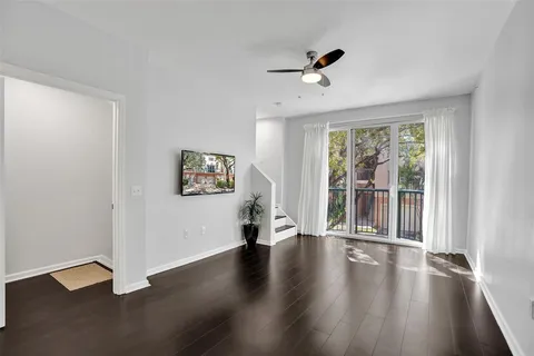 a view of an empty room with a window and wooden floor
