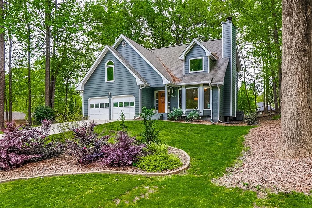 a view of a house with a yard and potted plants