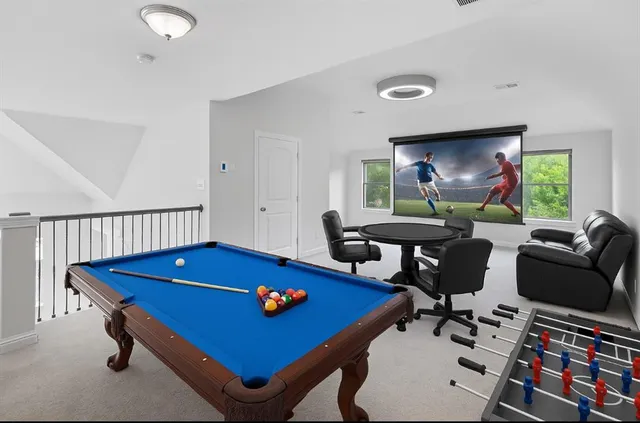 a living room with furniture and a pool table