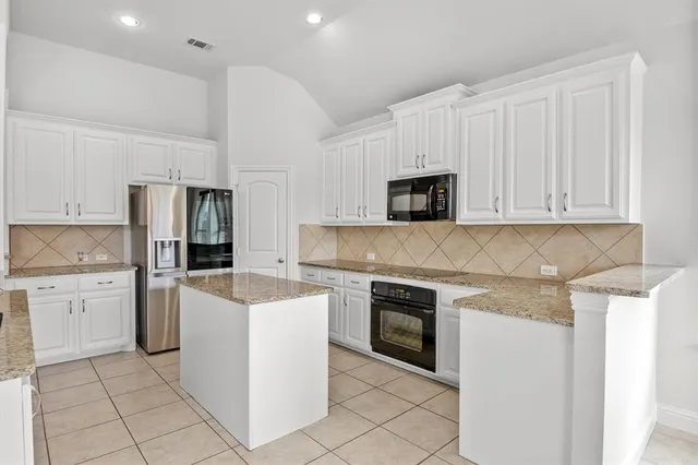a kitchen with white cabinets stainless steel appliances and sink