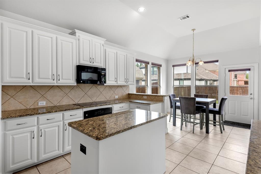 2610 Meadow Ridge Drive Prosper, TX 75078 - Photo 16 of 32 a kitchen with granite countertop white cabinets dining table and chairs