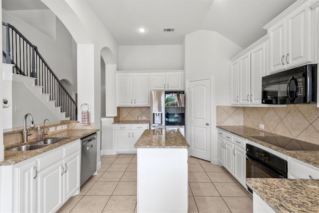 2610 Meadow Ridge Drive Prosper, TX 75078 - Photo 17 of 32 a kitchen with stainless steel appliances kitchen island granite countertop a sink and a stove