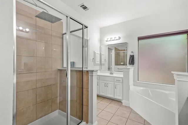 a bathroom with a granite countertop sink mirror and a bathtub