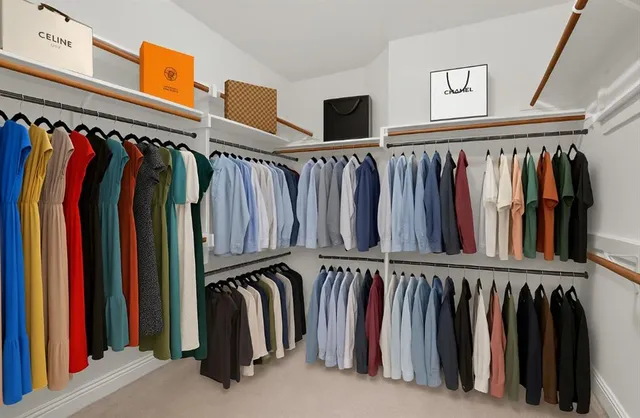 a view of walk in closet with clothes and shoes