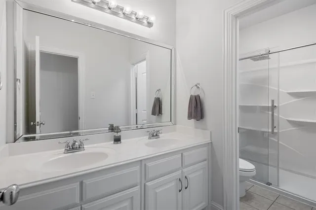 a bathroom with a double vanity sink and a mirror