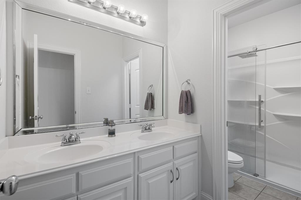 2610 Meadow Ridge Drive Prosper, TX 75078 - Photo 24 of 32 a bathroom with a double vanity sink and a mirror