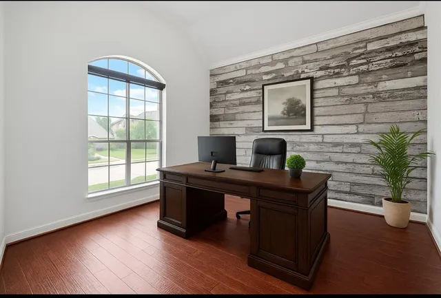 a view of a workspace with furniture and a window