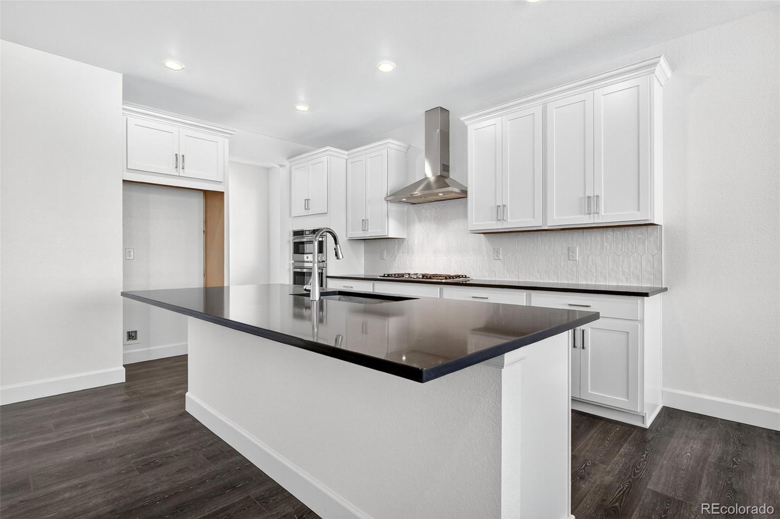 17095 West 92nd Loop Arvada, CO 80007 - Photo 11 of 37 a kitchen with kitchen island granite countertop a sink and a stove