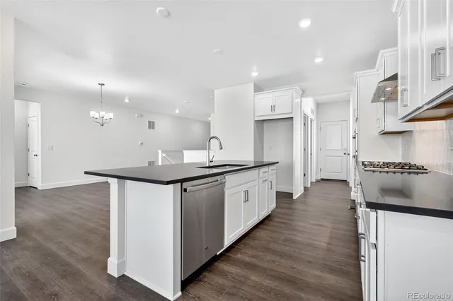 a kitchen with stainless steel appliances kitchen island granite countertop a stove a sink and a refrigerator