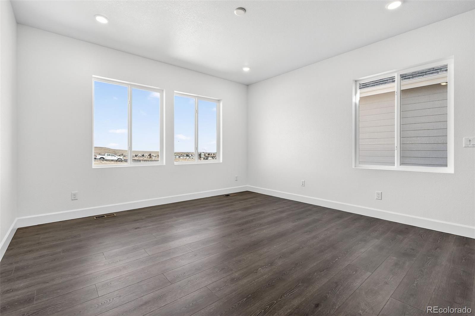 17095 West 92nd Loop Arvada, CO 80007 - Photo 14 of 37 an empty room with wooden floor and windows