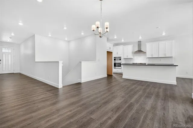 a view of a kitchen with wooden floor and a window
