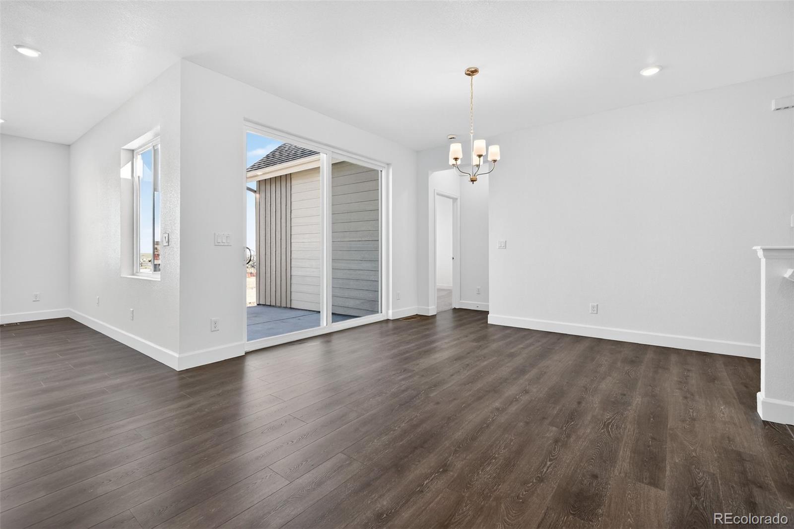 17095 West 92nd Loop Arvada, CO 80007 - Photo 4 of 37 an empty room with wooden floor and windows