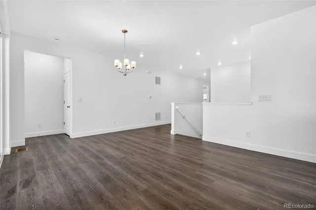 a view of a room with wooden floor and chandelier