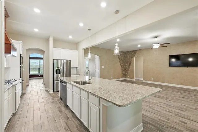 a spacious bathroom with a granite countertop sink a large mirror and shower