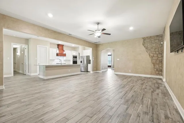 a view of empty room with wooden floor and fireplace