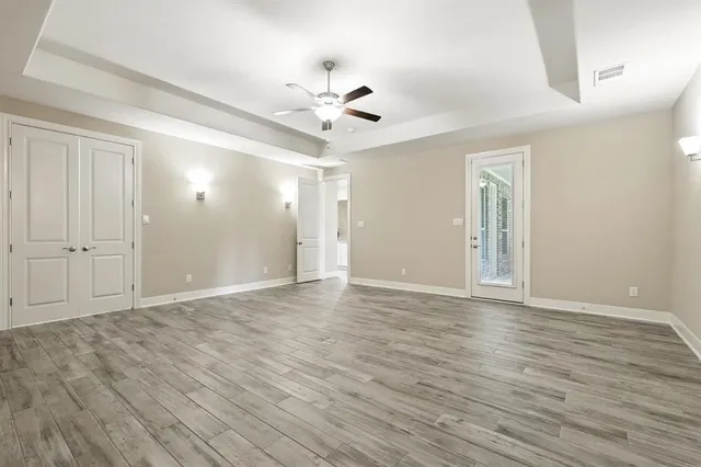 a view of a livingroom with wooden floor and a ceiling fan
