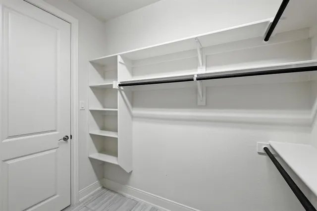 a view of an empty room with a chandelier fan