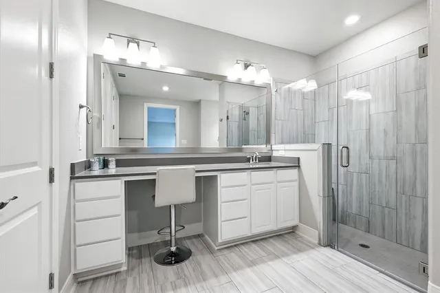 a bathroom with a sink double vanity granite tub and a mirror