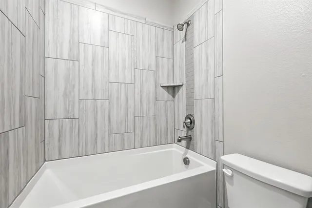 a bathroom with a granite countertop sink mirror toilet and bathtub