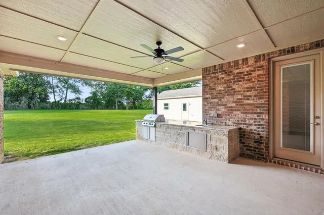 a patio with a table and chairs and potted plants