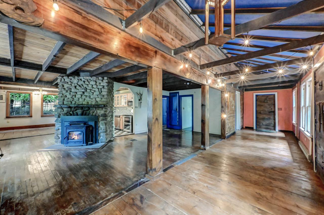 2285 Bear Town Road Canadensis, PA 18325 - Photo 17 of 58 a view of an empty room with wooden floor a fireplace and window