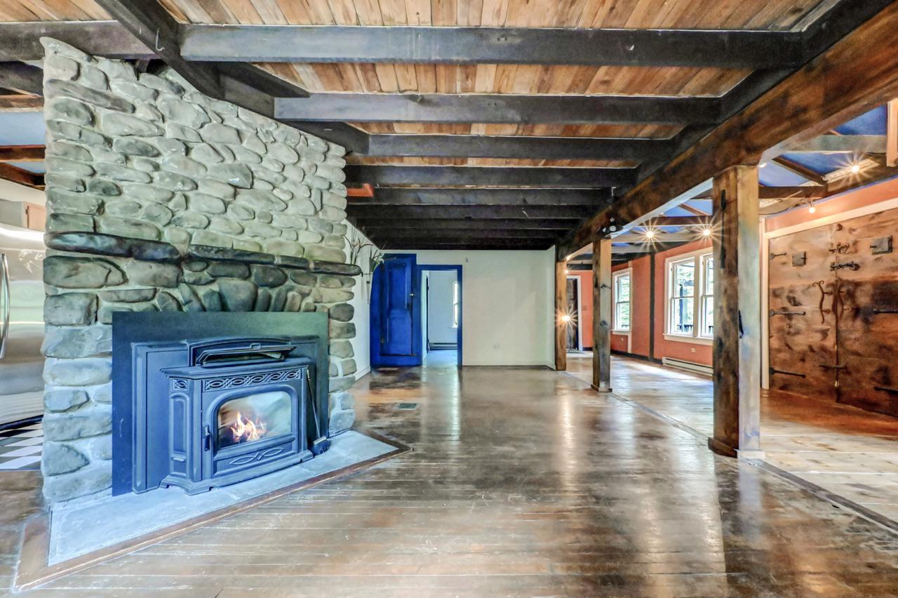 2285 Bear Town Road Canadensis, PA 18325 - Photo 20 of 58 a view of an empty room with wooden floor a fireplace and a window