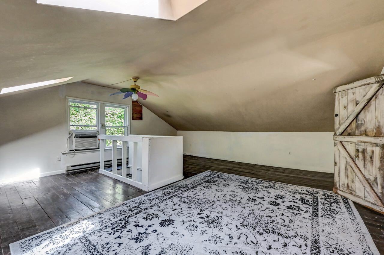 2285 Bear Town Road Canadensis, PA 18325 - Photo 38 of 58 a living room with a couch a rug and a stove with wooden floor