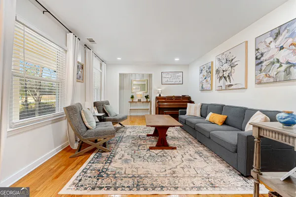a living room with furniture a rug and a window