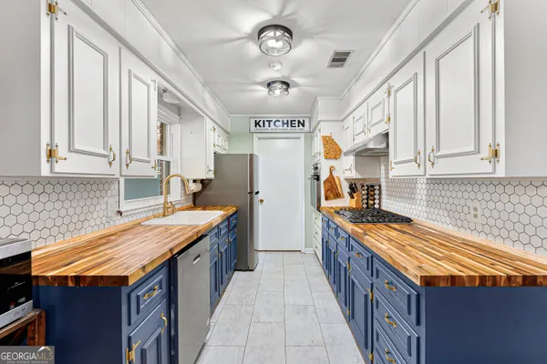 a open kitchen with stainless steel appliances granite countertop a dining table chairs and a wooden floor