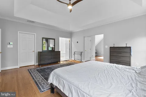 a bedroom with a bed a mirror on dresser and a chandelier