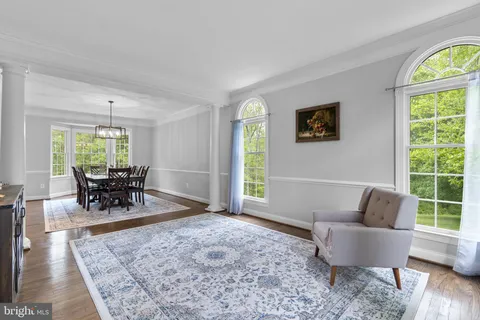 a dining room with furniture a chandelier and wooden floor